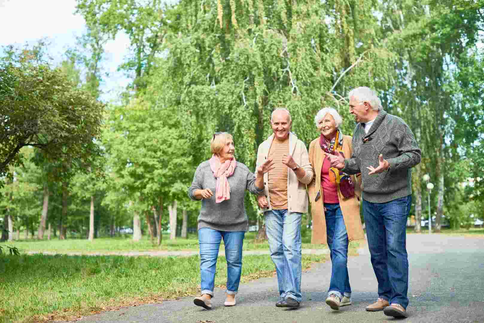 A group of seniors participating in outdoor activites as they take a nature walk through the park.