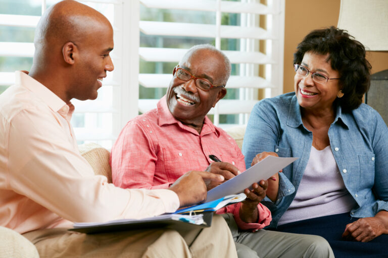 Two seniors talking with a financial advisor about investing after retirement.