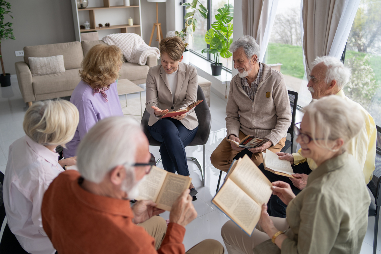 Group of seniors and a leader in a book club or Bible study circle