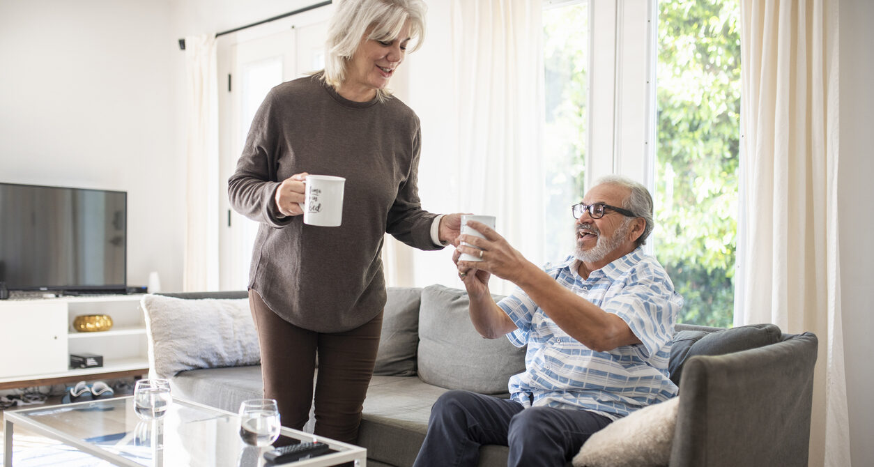 Senior woman bringing her husband some tea