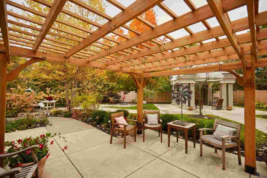 Outdoor pergola with seating area in a landscaped garden