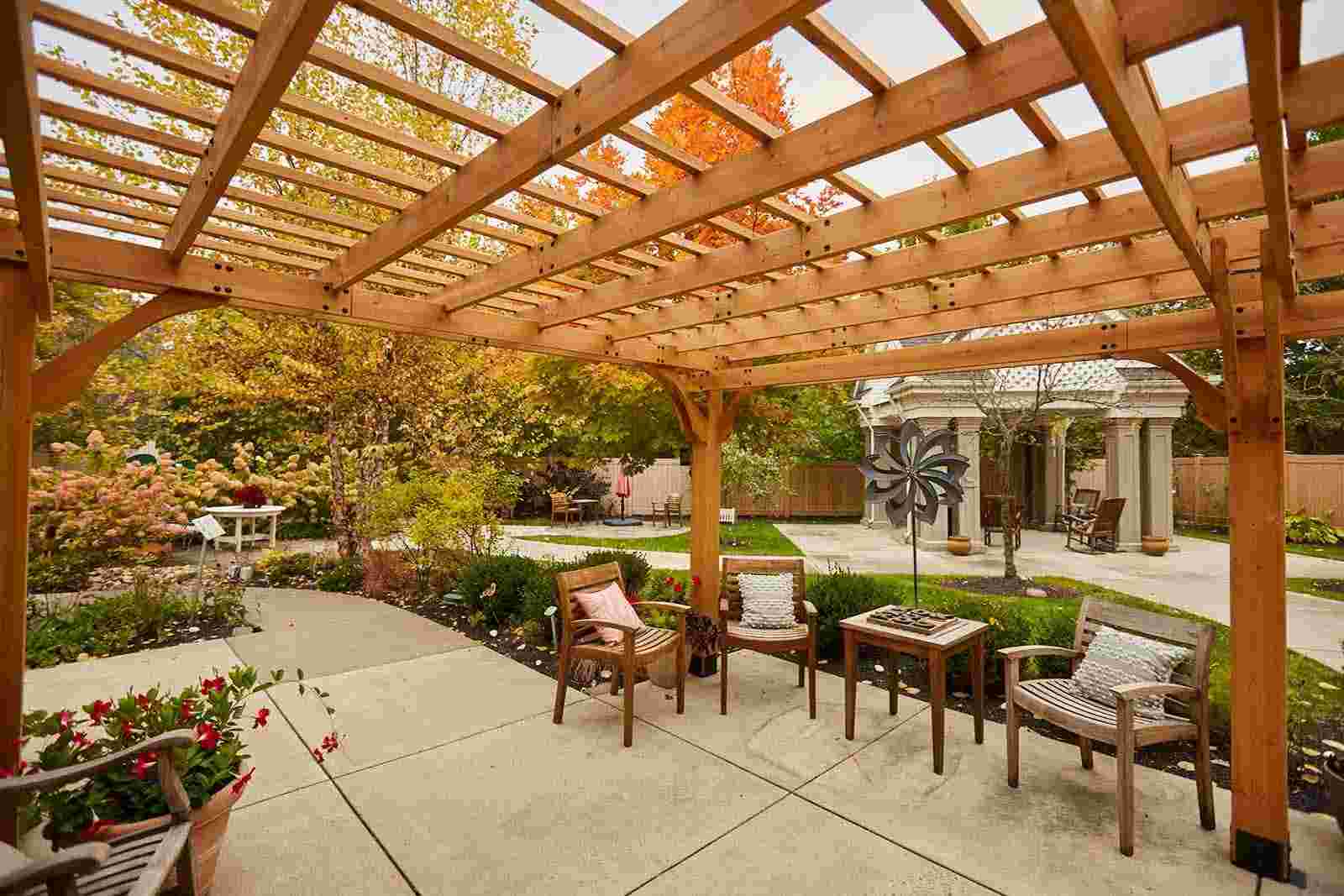 Outdoor pergola with seating area in a landscaped garden