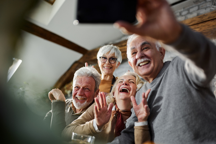 Group of four happy seniors taking a selfie together