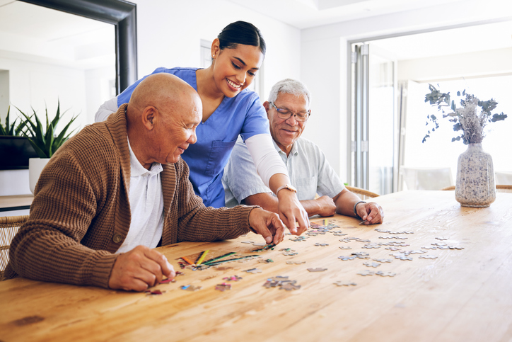 Caregiver helping seniors with a puzzle at Brookwood Point