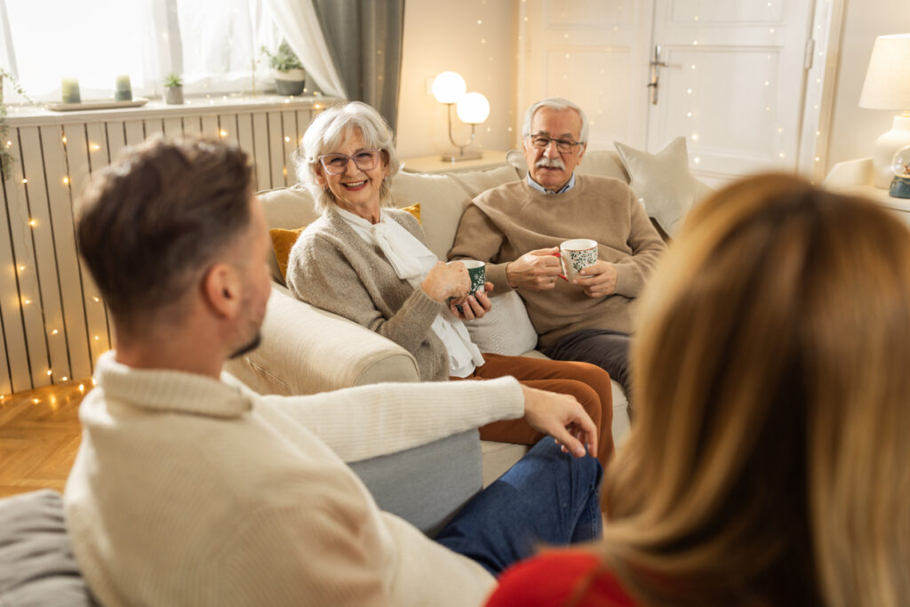 Seniors enjoying coffee and conversation with family in a cozy living room