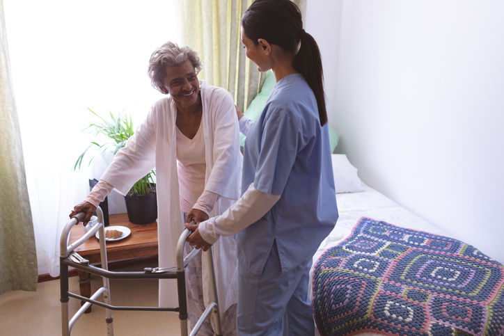 Senior getting helped by her care giver