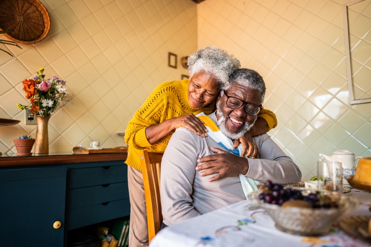Happy senior couple embracing at home
