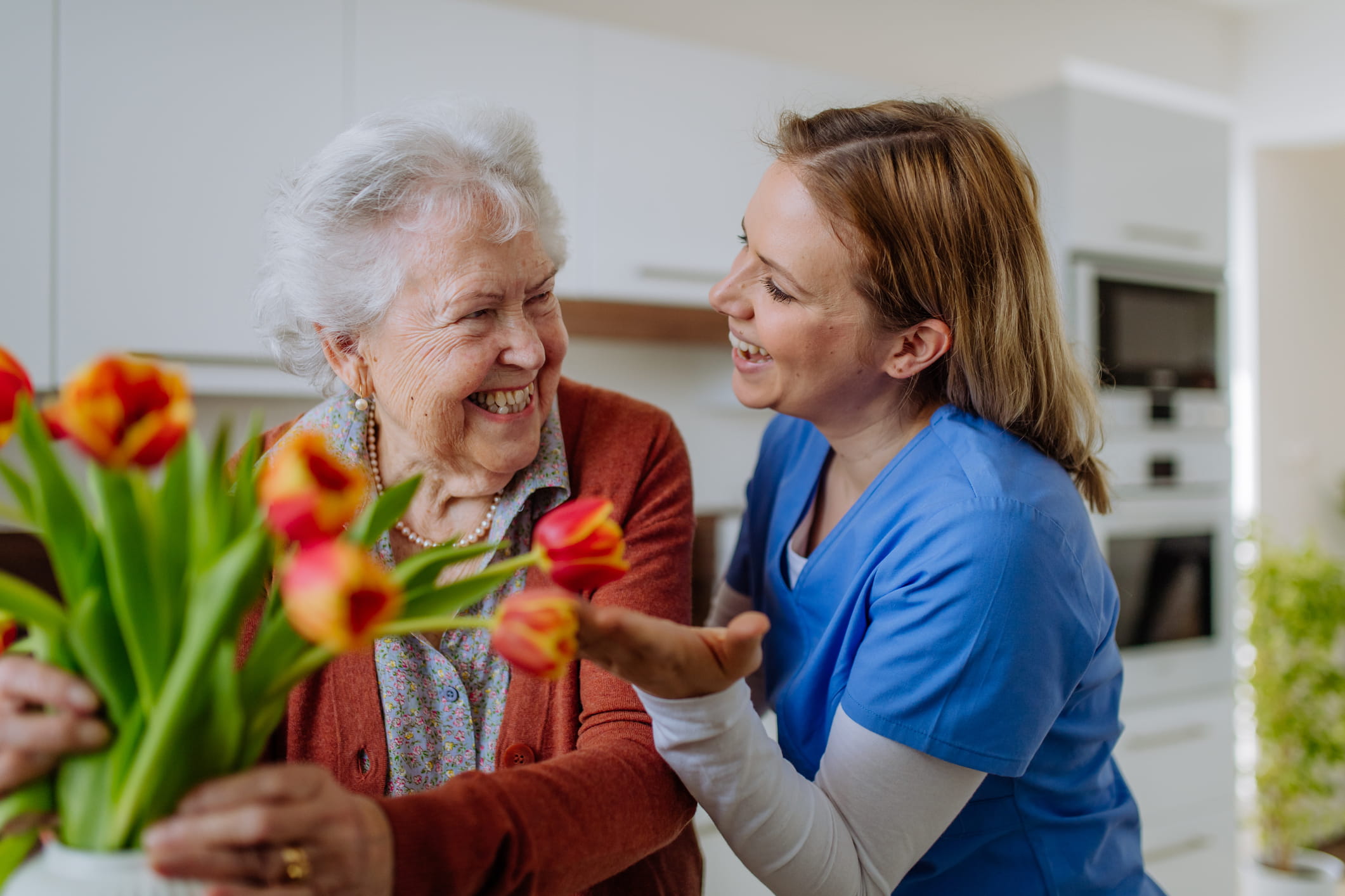 Caregiver giving resident her flowers